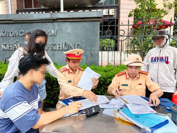 Thiếu tá Đặng Tuấn Long và Thượng úy Lê Ngọc Sơn làm việc với các trường hợp vi phạm giao thông.