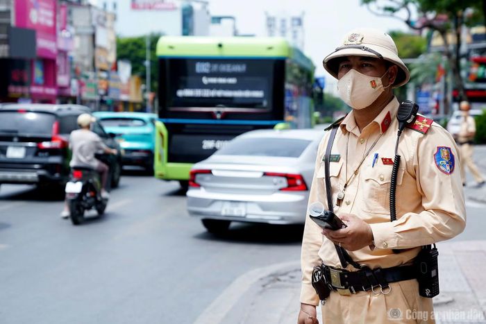 Cán bộ CSGT làm nhiệm vụ trên đường Nguyễn Văn Cừ dưới thời tiết nắng nóng.