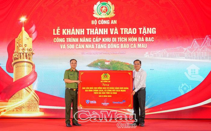 Thượng tướng Phạm Thế Tùng trao bảng tượng trưng bàn giao 500 căn nhà cho các hộ dân có hoàn cảnh khó khăn; đồng chí Ngô Vũ Thăng, Phó Chủ tịch UBND tỉnh Cà Mau tiếp nhận.