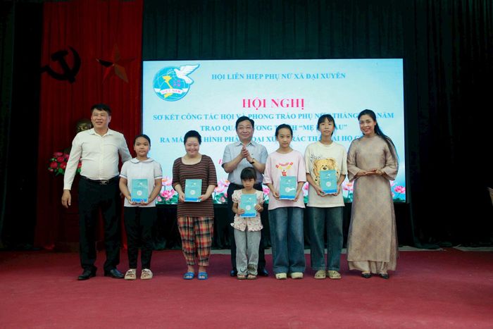 Lãnh đạo xã Đại Xuyên trao kinh phí "Mẹ đỡ đầu" cho trẻ em. Ảnh: Hồng Nhung