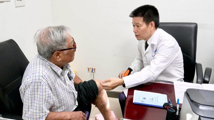 PGS.TS Lê Hữu Doanh, Giám đốc Bệnh viện Da liễu Trung ương khám, tư vấn cho người bệnh đang điều trị tại Bệnh viện Hữu Nghị.