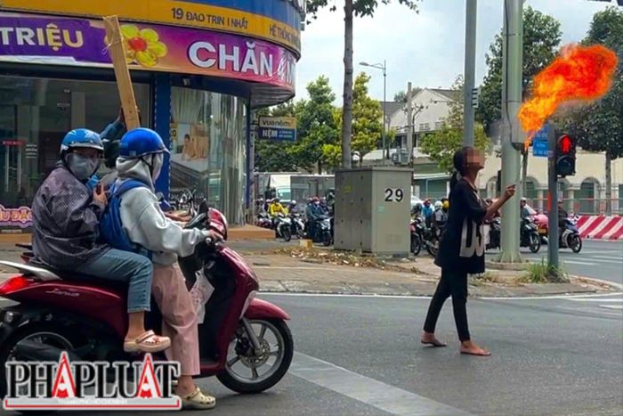  Ghi nhận PV Pháp Luật TP.HCM tại giao lộ Phạm Văn Đồng - Đào Trinh Nhất, một bé gái 13 tuổi biểu diễn phun lửa bằng dầu hỏa để kiếm tiền mưu sinh. Ảnh: NHÓM PV 