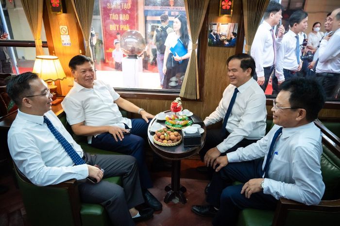  Thứ trưởng Y tế Đỗ Xuân Tuyên và Giám đốc Bệnh viện Bạch Mai Đào Xuân Cơ bên trong toa hành khách hướng về Phủ Lý. Toa tàu được thiết kế cụm ghế 4 người đối xứng kèm bàn trà, tạo sự thoải mái cho đoàn công tác và các chuyên gia trao đổi công việc dọc đường. 