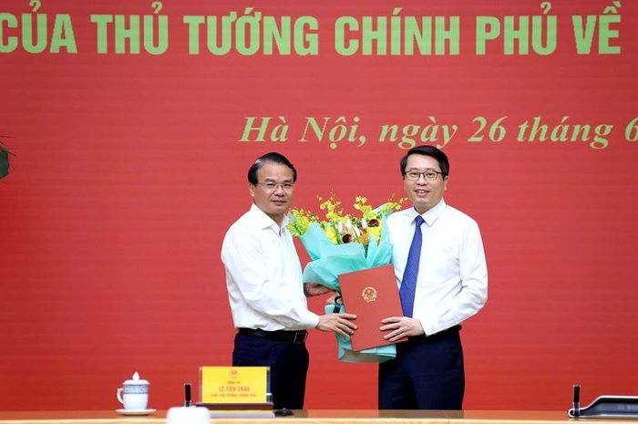 Bộ trưởng, Chủ nhiệm Văn phòng Chính phủ Đặng Xuân Phong tặng hoa chúc mừng Phó Chủ nhiệm Văn phòng Chính phủ Trần Anh Tiến - Ảnh: VGP/Thu Sa
