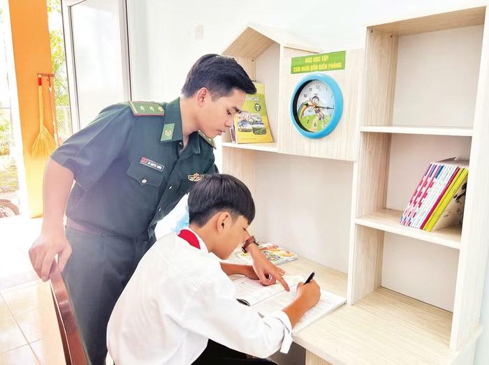 Em Nguyễn Thái Biển được cán bộ Đồn Biên phòng Cửa khẩu cảng Giao Long hướng dẫn làm bài tập sau giờ lên lớp. (Ảnh: HOÀNG TRUNG)