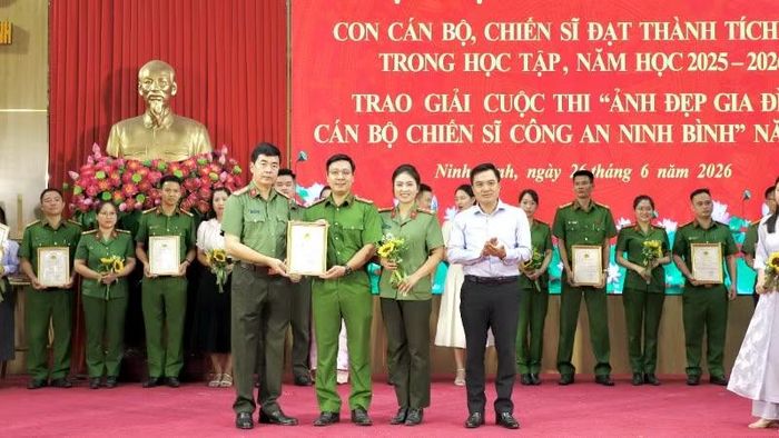 Đồng chí Phó Giám đốc Công an tỉnh Ninh Bình Trần Xuân Phú và đồng chí Vũ Văn Lúa, Trưởng Văn phòng đại diện Báo Nhân Dân tại Ninh Bình tặng hoa, trao giải cho các gia đình.