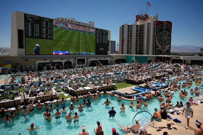 Các du khách đang bơi trong hồ bơi của Circa Resort &amp; Casino ở Las Vegas dõi theo trận đấu mà đội tuyển Mỹ vượt qua Australia. Ảnh: AP