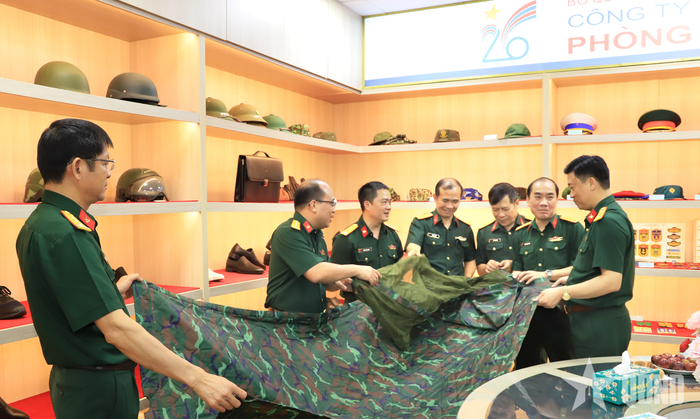Các đại biểu nghe giới thiệu sản phẩm quân nhu đa năng "5 trong 1" (gồm màn, tăng, võng, chiếu, gối) do Công ty Cổ phần 26 nghiên cứu, sản xuất thử nghiệm theo yêu cầu của Bộ Quốc phòng.