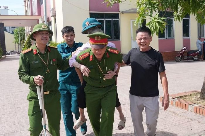 Cụ bà được cán bộ Công an cõng đến điểm lấy mẫu ADN.