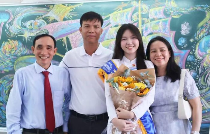 Thầy chủ nhiệm Nguyễn Văn Quyết (bìa trái) chụp ảnh cùng gia đình nữ sinh Hương Giang.