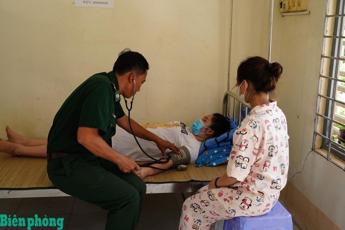 Cán bộ quân y Đồn Biên phòng cửa khẩu quốc tế Vĩnh Xương khám sức khỏe, động viên công dân sau khi tiếp nhận. Ảnh: Tiến Vinh