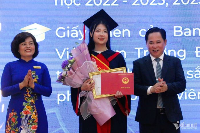 Nữ sinh Nguyễn Thu Trang, lớp KT17C, khoa Kế toán, thủ khoa toàn khóa của Trường ĐH Công đoàn nhận bằng tốt nghiệp từ lãnh đạo nhà trường. Ảnh: Thanh Hùng