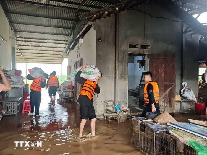 Lực lượng công an hỗ trợ người dân xã Hòa An di dời tài sản. (Ảnh: TTXVN phát)