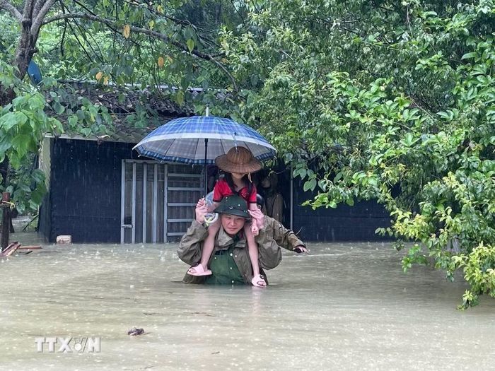 Lực lượng vũ trang hỗ trợ di dời trẻ em ra vùng an toàn. (Ảnh: TTXVN phát)