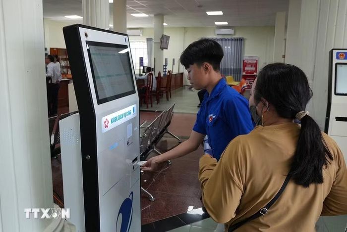 Hỗ trợ người dân lấy số để làm hồ sơ, thủ tục tại Trung tâm phục vụ hành chính công phường Rạch Giá (An Giang). (Ảnh: Lê Huy Hải/TTXVN)