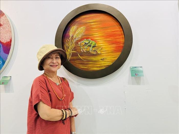 Họa sĩ Maria Andriana bên tác phẩm “Đừng đi”.