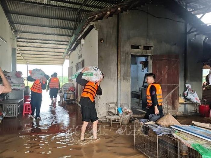 Lực lượng công an hỗ trợ người dân xã Hòa An di dời tài sản. Ảnh: TTXVN phát