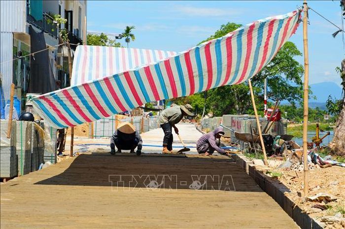 Các công nhân che bạt để tránh nắng nóng khi làm việc.