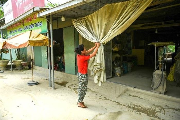 Do bụi bay mù mịt từ Quốc lộ 14D xuống cấp, nhiều hộ dân dọc tuyến phải căng rèm để hạn chế bụi bay vào nhà.