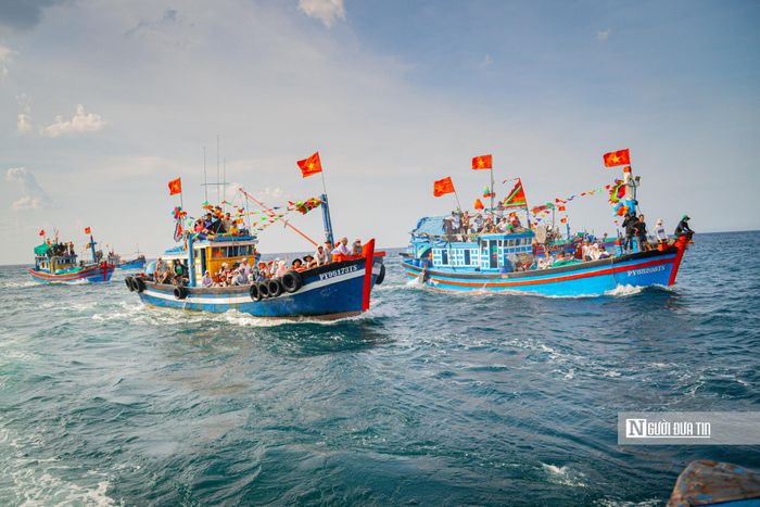 Theo sau đoàn là hàng chục tàu khác của ngư dân trong làng, nối đuôi nhau vươn khơi. Những chiếc tàu chạy khuấy động cả vùng biển trước làng.