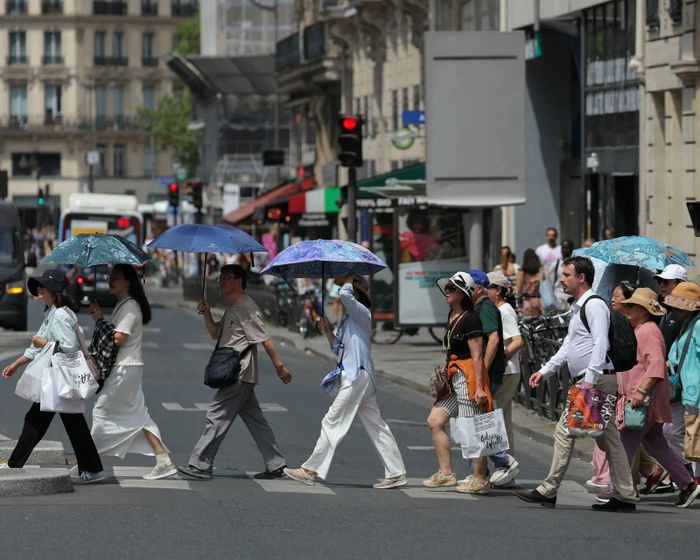 Du khách sử dụng ô để tránh nắng tại thủ đô Paris, France ngày 23/6/2026. Ảnh: AFP.