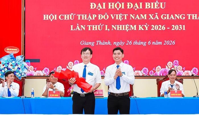 Phó Chủ tịch Thường trực Ủy ban MTTQ Việt Nam xã Giang Thành Nguyễn Hồng Kông tặng hoa chúc mừng Chủ tịch danh dự Hội Chữ thập đỏ xã Giang Thành Võ Văn Bình.