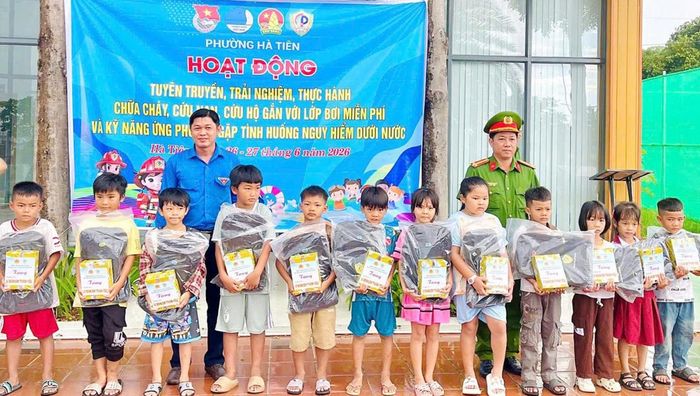 Bí thư Đoàn phường Hà Tiên Trần Tấn Phát và Trung tá Nguyễn Thắng Anh, Phó Đội trưởng Đội Chữa cháy và Cứu nạn, cứu hộ khu vực Hà Tiên tặng quà cho các học sinh.