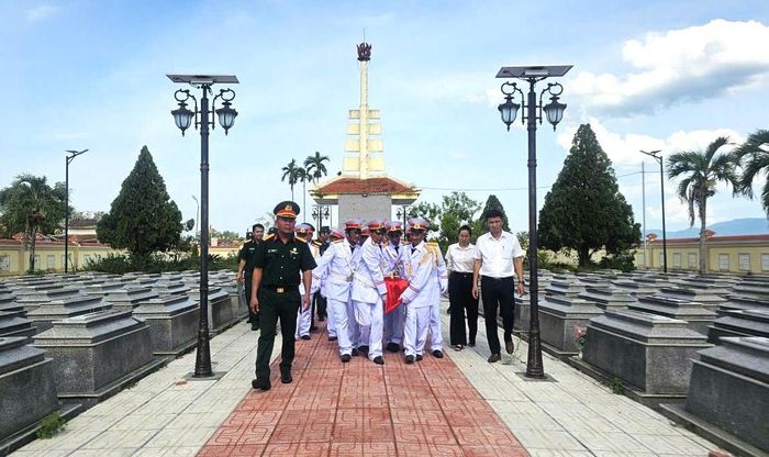 Lực lượng chức năng di chuyển hài cốt liệt sĩ đến nơi an táng. Ảnh: LAM PHƯƠNG
