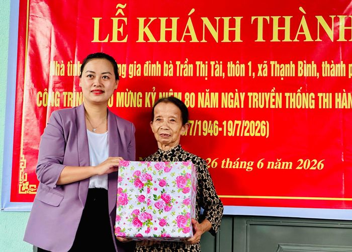 Đại diện lãnh đạo xã Thạnh Bình tặng quà chúc mừng gia đình bà Trần Thị Tài nhân khánh thành nhà mới. Ảnh: ALĂNG NGƯỚC 