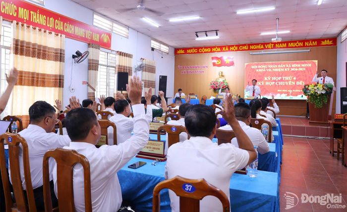 Các đại biểu biểu quyết thông qua nghị quyết về sắp xếp, tổ chức lại các ấp trên địa bàn xã Bình Minh. Ảnh: Thanh Tâm