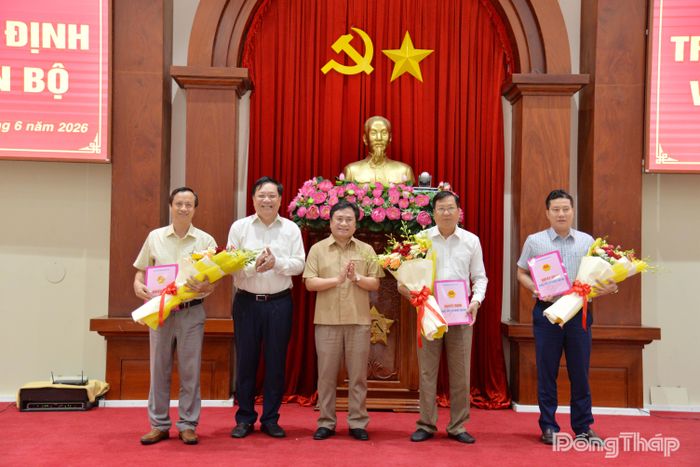 Đồng chí Phạm Thành Ngại trao quyết định bổ nhiệm và đồng chí Trần Văn Dũng, Phó Chủ tịch Thường trực UBND tỉnh Đồng Tháp tặng hoa chúc mừng các đồng chí được bổ nhiệm lãnh đạo Trung tâm Phát triển Quỹ đất tỉnh.