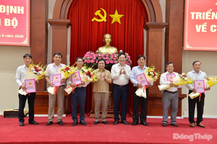 Đồng chí Phạm Thành Ngại trao quyết định bổ nhiệm và đồng chí Trần Văn Dũng, Phó Chủ tịch Thường trực UBND tỉnh Đồng Tháp tặng hoa chúc mừng các đồng chí được bổ nhiệm lãnh đạo Ban Quản lý dự án đầu tư xây dựng công trình giao thông tỉnh Đồng Tháp.