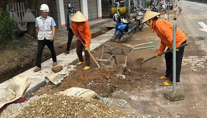  Lực lượng công nhân đang sửa chữa mặt đường, cầu, rãnh dọc đoạn qua địa bàn phường Hoài Nhơn Bắc. Ảnh: N.L 