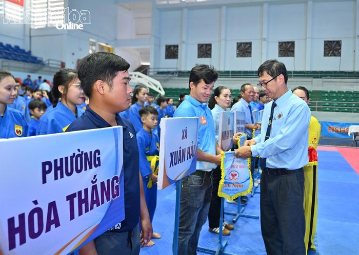 Ban tổ chức tặng cờ lưu niệm cho đại diện các đơn vị tham dự giải.