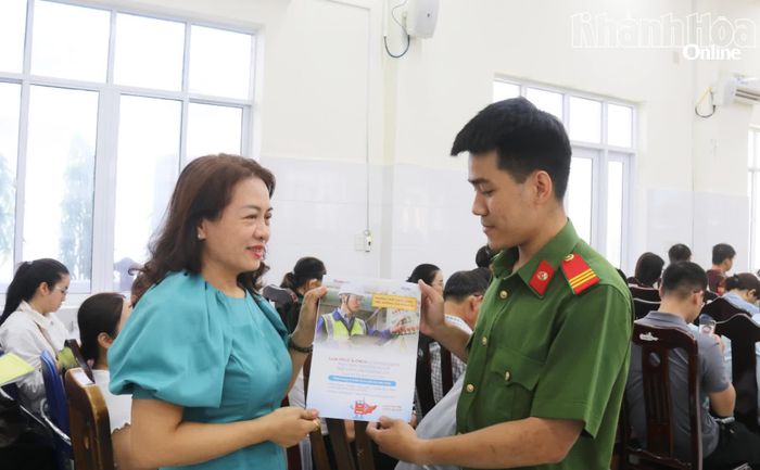 Công an phường Nam Nha Trang phát tờ rơi hướng dẫn kết nối thiết bị truyền tin báo cháy cho đại biểu.