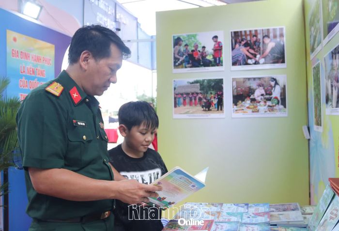 Bố và con cùng đọc sách tại gian hàng trưng bày của các địa phương.