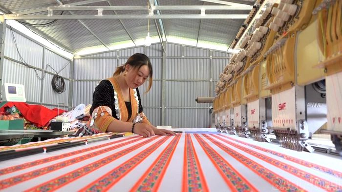 Chị Cứ Thị Gua với hệ thống máy móc hiện đại sản xuất trang phục dân tộc Mông.