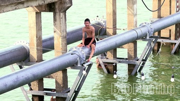 Không chỉ nhảy từ trên cao xuống mặt nước, một số thanh thiếu niên còn ngồi, đi lại trên đường ống dẫn nước tại khu vực lòng hồ, bất chấp biển cảnh báo.