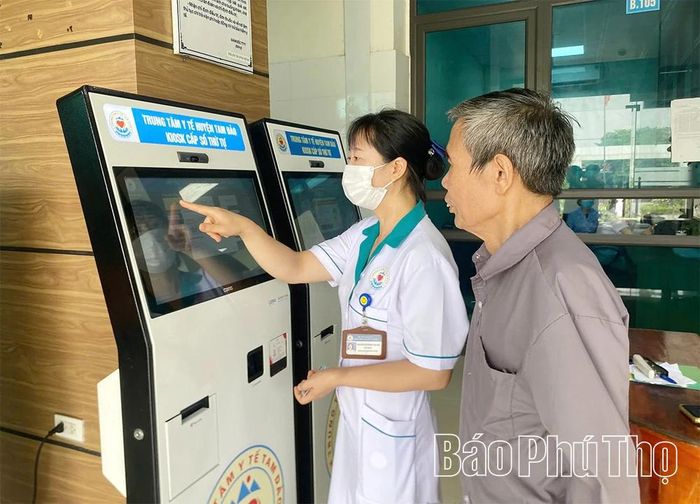 Nhân viên Trung tâm Y tế khu vực Tam Đảo hỗ trợ bệnh nhân lấy số đăng ký khám bệnh.