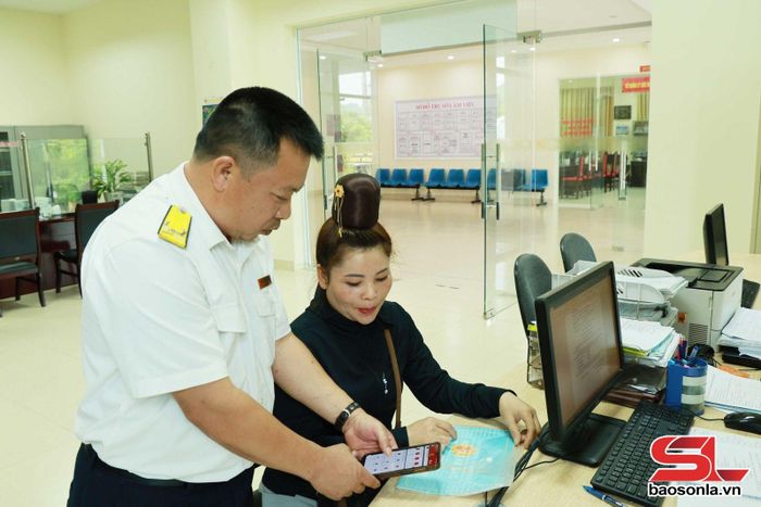 Công chức thuế hướng dẫn người nộp thuế cài đặt ứng dụng eTax Mobile.