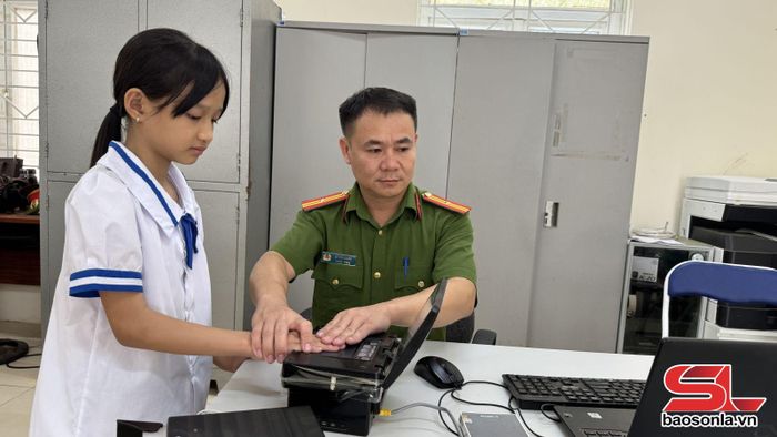 Công an xã Yên Châu hỗ trợ làm căn cước công dân cho trẻ em.