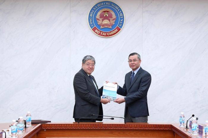 Phó Tổng thư ký OECD Yasushi Masaki trao Báo cáo rà soát chất lượng FDI của Việt Nam do OECD chủ trì phối hợp với Bộ Tài chính Việt Nam thực hiện tới Bộ trưởng Ngô Văn Tuấn. Ảnh: Đức Minh
