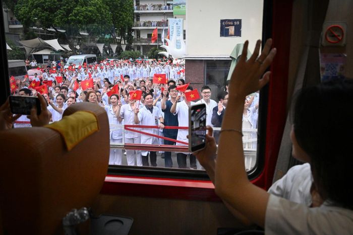 Hàng trăm y bác sĩ tại Bệnh viện Bạch Mai cơ sở 1 vẫy chào "Đoàn tàu Bạch Mai" đưa hơn 500 đồng nghiệp đến cơ sở Ninh Bình. Ảnh: Bình An
