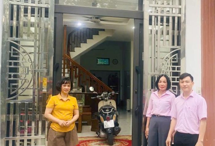Niềm vui của chị Trần Thị Kim Hương (trái) trong căn nhà mới xây từ nguồn vốn vay của NHCSXH