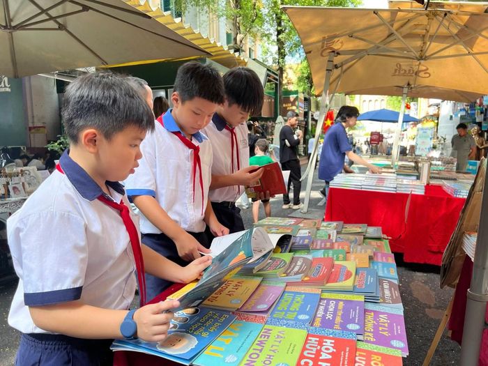 Các em học sinh tìm đọc sách tại Hội sách thiếu nhi ở Đường sách TP Hồ Chí Minh sáng 26/6.