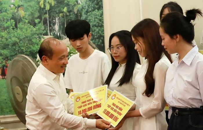 Ông Nguyễn Thanh Hiền - Chủ tịch Hội Khuyến học tỉnh Nghệ An trao học bổng cho các em học sinh. Ảnh: Quốc Huy