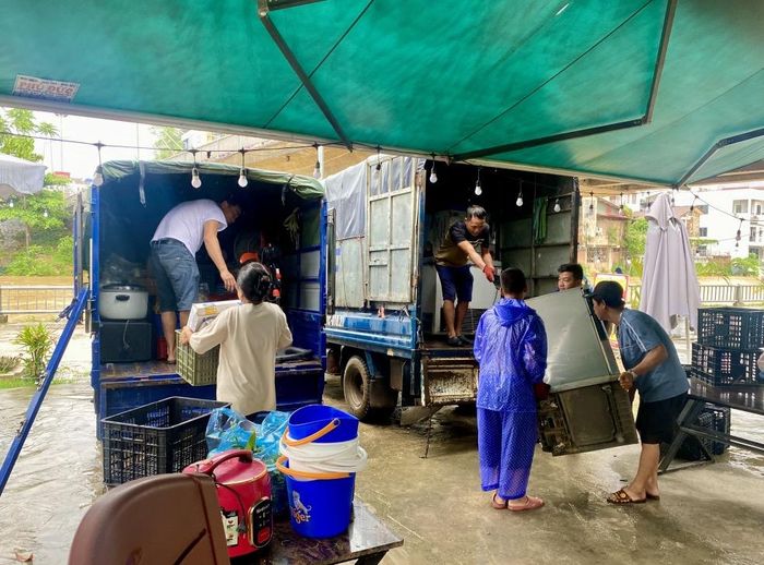 Các hộ kinh doanh chủ động di dời hàng hóa trước nguy cơ nước lũ dâng cao.