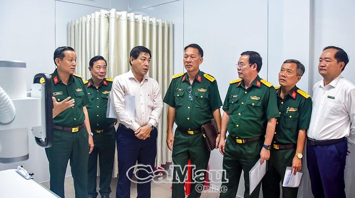 Thượng tá Mã Hồng Anh, Giám đốc Bệnh viện Quân Dân y Bạc Liêu (bìa trái), giới thiệu về máy X-quang kỹ thuật số tích hợp trí tuệ nhân tạo (AI) đến các đại biểu.
