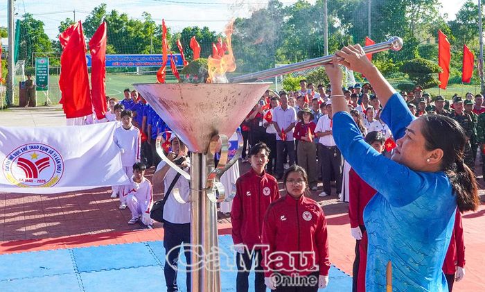  Đồng chí Nguyễn Trúc Ly, Bí thư Đảng ủy, Chủ tịch HĐND Xã Phan Ngọc Hiển, thực hiện nghi thức thắp đuốc Đại hội TDTT.