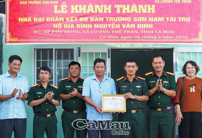 Đại diện lãnh đạo Xã Lương Thế Trân trao bảng ghi nhận tấm lòng vàng cho Ban Trường Sơn Nam, Binh đoàn 12.